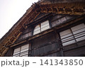 合掌造り古民家の茅葺き屋根と障子窓 曇り空を背景にした伝統家屋 141343850