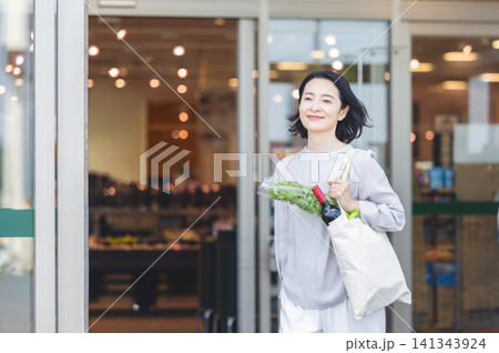 スーパーで買い物を終えて笑顔で出てくるミドル女性 スーパーで買い物を終えて笑顔で出てくるミドル女性 141343924