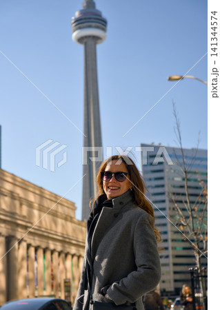 Smiling Woman Poses Near Iconic Tower And Historic Building Smiling Woman Poses Near Iconic Tower And Historic Building 141344574