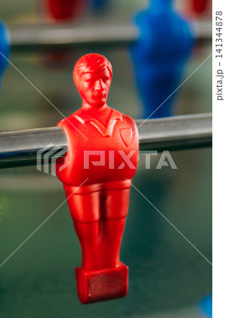 Close-up of a red plastic player on a foosball table. 141344878