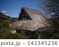 青空と山並みを背景にした合掌造りの茅葺き屋根 妻壁の装飾意匠 141345236