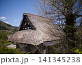 青空と山並みを背景にした合掌造りの茅葺き屋根 妻壁の装飾意匠 141345238