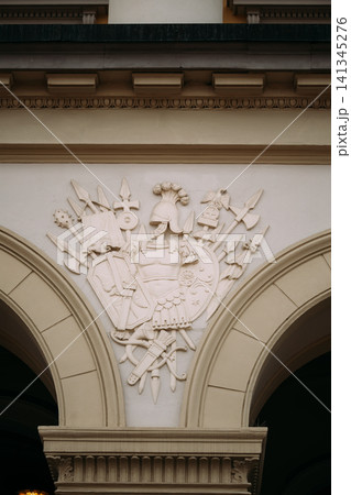 Bas-relief On Wall Of Royal Palace In Oslo, Norway. Ornate stone coat of arms carving on the Royal Palace facade in Oslo. Bas-relief On Wall Of Royal Palace In Oslo, Norway. Ornate stone coat of arms carving on the Royal Palace facade in Oslo. 141345276