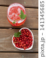 Top view red currant juice glass with bowl of fresh currants on wooden table 141345685