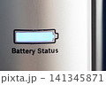 Closeup of illuminated battery icon and partial printed status on metallic device panel with blue glow, textured surface, soft side lighting, and shallow focus, with battery, icon, indicator, status 141345871