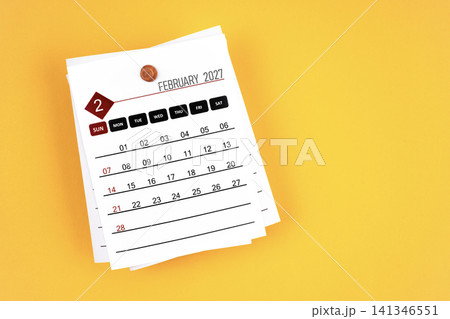 February 2027 calendar page with wooden push pin on yellow background. 141346551