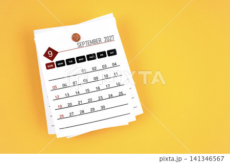 September 2027 calendar page with wooden push pin on yellow background. September 2027 calendar page with wooden push pin on yellow background. 141346567