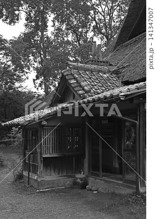 情趣漂う瓦屋根の下屋　茅葺きに寄り添う歴史ある古民家のガラス戸と縁側 141347007