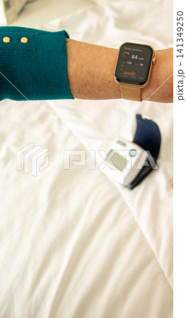 Wrist monitor shows health data while resting on the bed Wrist monitor shows health data while resting on the bed 141349250
