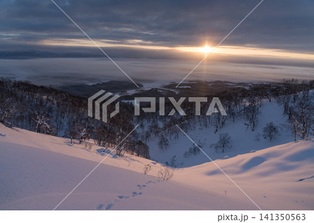 日の出の黄金の太陽柱と雪の谷の風景 141350563