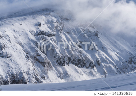 雪の火山稜線に渦巻くドラマチックな雲の情景 雪の火山稜線に渦巻くドラマチックな雲の情景 141350619