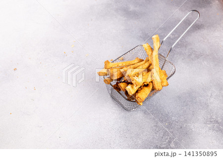 Crispy golden french fries in metal basket 141350895