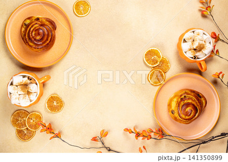 Autumn hot beverage with cinnamon rolls and dried oranges 141350899