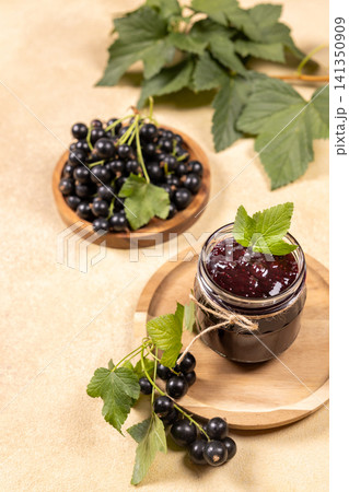 Blackcurrant jam jar with fresh berries and leaves Blackcurrant jam jar with fresh berries and leaves 141350909