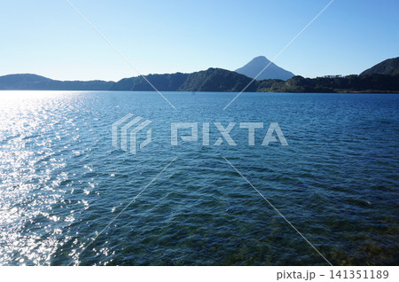 青空と丘に囲まれた池田湖の穏やかな風景 青空と丘に囲まれた池田湖の穏やかな風景 141351189