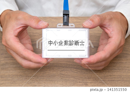 中小企業診断士の名札を持つ男性の手元 141351550