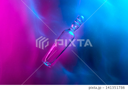 Glass ampoule illuminating glowing pink and blue liquid Glass ampoule illuminating glowing pink and blue liquid 141351786