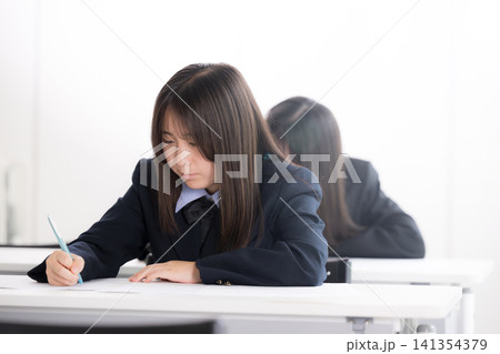 綺麗な新緑背景の教室で真剣にテストに取り組む日本人女子高校生複数 受験、定期テストや英検の模試の学生 綺麗な新緑背景の教室で真剣にテストに取り組む日本人女子高校生複数 受験、定期テストや英検の模試の学生 141354379
