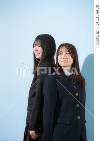 水色背景の未来を見つめて笑顔を見せる日本人女子高校生　2人で夢や進路を考える学校生活横顔 141354430