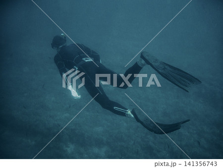 Freediver Swimming Underwater in Blue Ocean with Fins 141356743