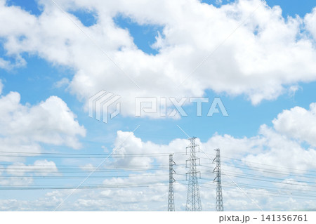 Power Lines and Transmission Towers Under Blue Cloudy Sky Power Lines and Transmission Towers Under Blue Cloudy Sky 141356761