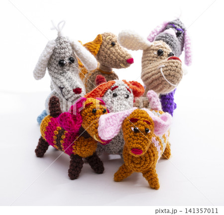 Several knitted woolen dogs on a white background Several knitted woolen dogs on a white background 141357011