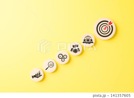 Business goals and target achievement concept. Icons arranged in rising toward bullseye target representing goal setting, growth, strategy execution, teamwork, successful business outcomes, objective, Business goals and target achievement concept. Icons arranged in rising toward bullseye target representing goal setting, growth, strategy execution, teamwork, successful business outcomes, objective, 141357605