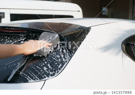 車のバックドアガラスを洗う手元 141357999