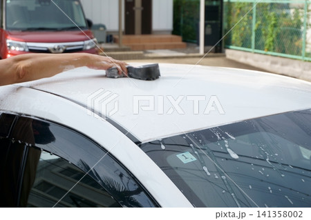 車のルーフをスポンジで洗う手元 141358002