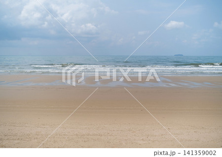 Wide open empty sandy beach with gentle sea waves and soft cloudy sky stretching to the horizon. Peaceful seascape concept Wide open empty sandy beach with gentle sea waves and soft cloudy sky stretching to the horizon. Peaceful seascape concept 141359002