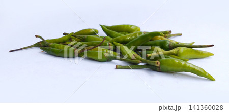 A pile of fresh green bird's eye chilies against a white background. A pile of fresh green bird's eye chilies against a white background. 141360028