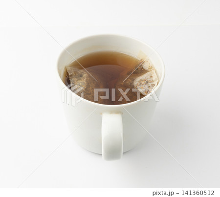 Herbal tea sachet in cup, hot water with chamomile and Hypericum or St. John's wort teabag Herbal tea sachet in cup, hot water with chamomile and Hypericum or St. John's wort teabag 141360512