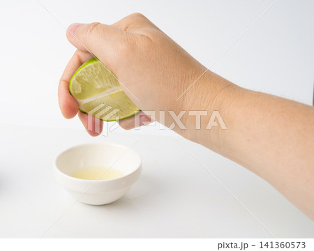 Squeezed lime isolated, squeezed out half green lemon on white background, burnout symbol Squeezed lime isolated, squeezed out half green lemon on white background, burnout symbol 141360573