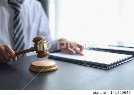 Lawyer Reviewing Contract and Documents with Gavel on Desk. Lawyer Reviewing Contract and Documents with Gavel on Desk. 141360647