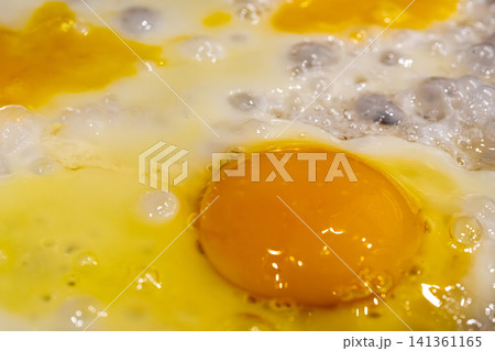 Fry eggs on pan closeup, fried cooked egg yolk and white with bubbles texture Fry eggs on pan closeup, fried cooked egg yolk and white with bubbles texture 141361165
