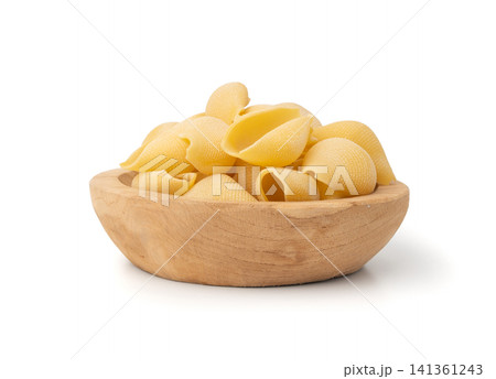 Raw conchiglioni pasta isolated. Dry conchiglie noodle in shell shape, big Italian macaroni Raw conchiglioni pasta isolated. Dry conchiglie noodle in shell shape, big Italian macaroni 141361243