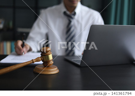 Lawyer Reviewing Contract with Gavel on Desk. 141361794