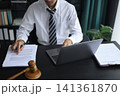 Lawyer Reviewing Contract with Gavel on Desk. 141361870
