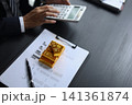 Gold investment Concept. Businessman working on financial planning and gold investment analysis with bullion and calculator. 141361874