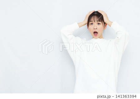 頭を抱えて驚く女性 頭を抱えて驚く女性 141363394