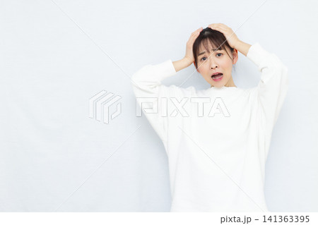 頭を抱えて驚く女性 頭を抱えて驚く女性 141363395