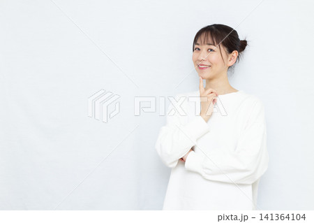 笑顔で悩んでいる女性 141364104