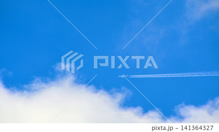 青空と白い雲の中を飛ぶジェット機 青空と白い雲の中を飛ぶジェット機 141364327