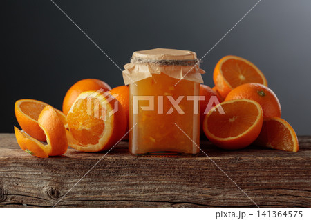 Homemade orange jam in a glass jar on on a black background. Homemade orange jam in a glass jar on on a black background. 141364575