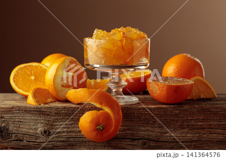 Orange marmalade in a glass dessert bowl on an old wooden table. Orange marmalade in a glass dessert bowl on an old wooden table. 141364576