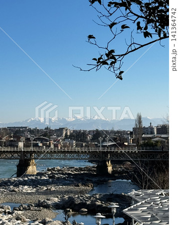 Bridge over Rioni River with view of snow-capped Caucasus Mountains in Kutaisi, Georgia Bridge over Rioni River with view of snow-capped Caucasus Mountains in Kutaisi, Georgia 141364742