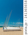 Small sailboats stored on a sandy beach along the Mediterranean coast of Spain. Vertical composition with turquoise sea 141365658