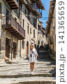 Woman in white dress standing on medieval stone street in Rupit village, Catalonia, Spain 141365659