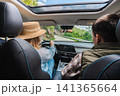 Couple traveling by car on scenic mountain road viewed from rear seats 141365664