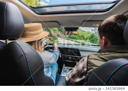 Couple traveling by car on scenic mountain road viewed from rear seats Couple traveling by car on scenic mountain road viewed from rear seats 141365664